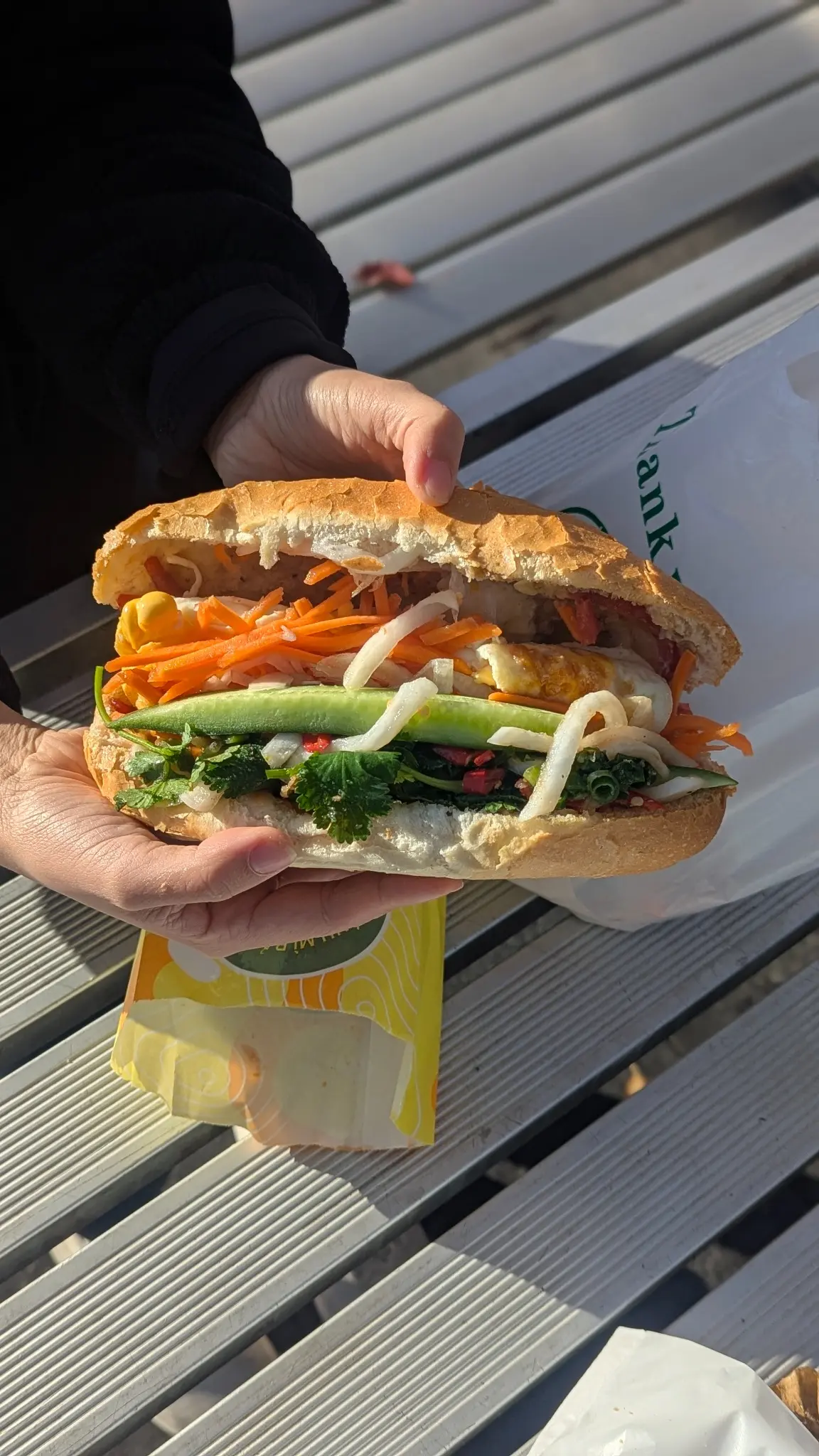 Banh Mi Bay Ngo nem nuong and fried egg banh mi held outside the Bankstown bakery